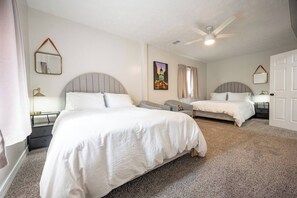 A hotel room with two beds, a ceiling fan, a painting, and a door. - 10 Min to Lucas Oil~Walk to Mass Ave~Hot Tub (Indianapolis)