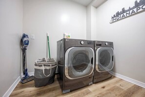 A laundry room with two front-loading LG washers, a vacuum cleaner, and a mop. - 10 Min to Lucas Oil~Walk to Mass Ave~Hot Tub (Indianapolis)