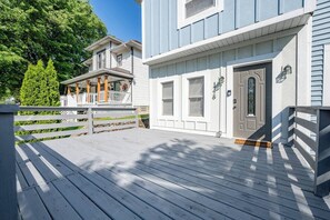 Ein zweistöckiges Haus mit einer Veranda und einer Haustür mit Hausnummer.