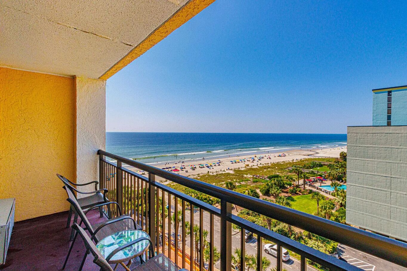 A balcony with a view of a beach and ocean.
