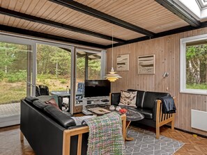 A modern living room with a black leather sofa, a wooden coffee table, and a television. - "Hardina" - 1km from the sea by Interhome (Vejers Strand)