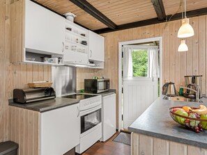 A modern kitchen with white cabinetry, stainless steel appliances, and a wooden ceiling. - "Hardina" - 1km from the sea by Interhome (Vejers Strand)