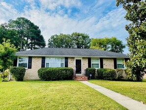 A single-story house with a brick facade, a front porch, and a well-maintained lawn. - Peaceful 4-bedroom ranch in Richmond’s west end. (Richmond)