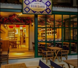 A restaurant with outdoor seating and a sign above the entrance. - Perto da Praia - Botafogo - HOTSPOT (Rio de Janeiro)