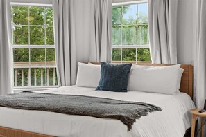 A bed with white bedding, a dark blue pillow, and a grey throw blanket. - The One on the Water & 2BDR (Kimberling City)