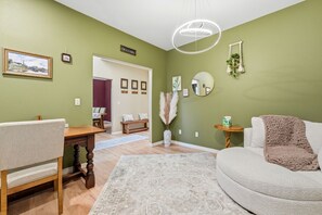 Ein Wohnzimmer mit einer Couch, einem Holztisch und einem Essbereich mit Stühlen.