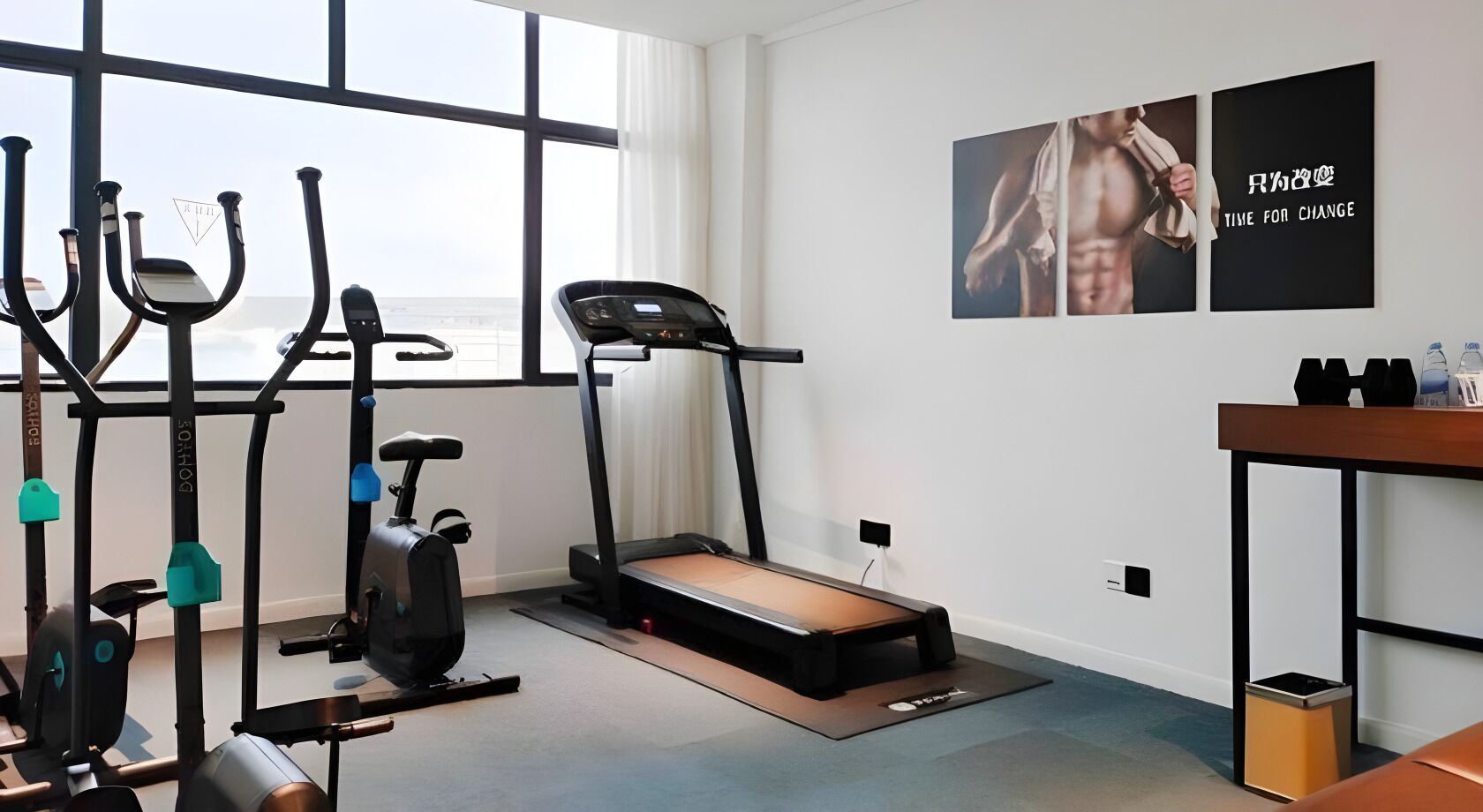 Ein Heimfitnessraum mit Laufband, Ergometer und Rudergerät.