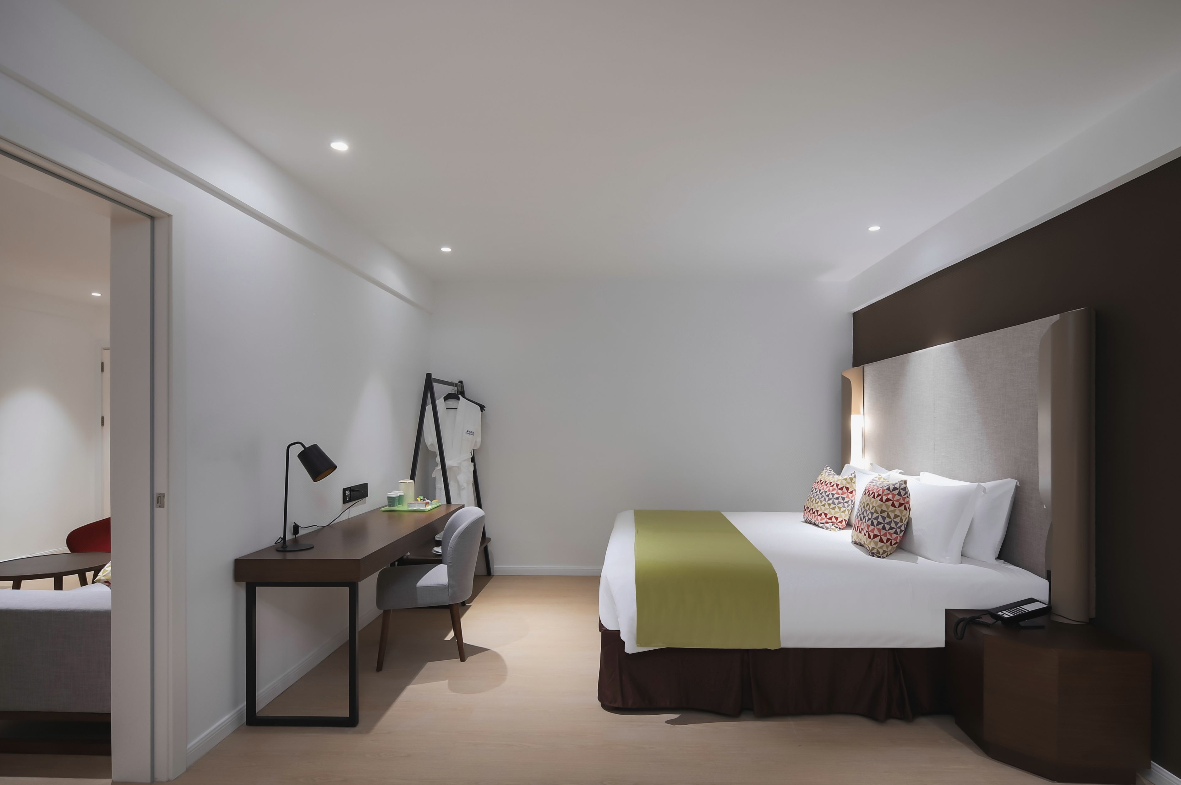 Une chambre d’hôtel équipée d’un lit, d’un bureau, d’une chaise et d’un porte-manteau.