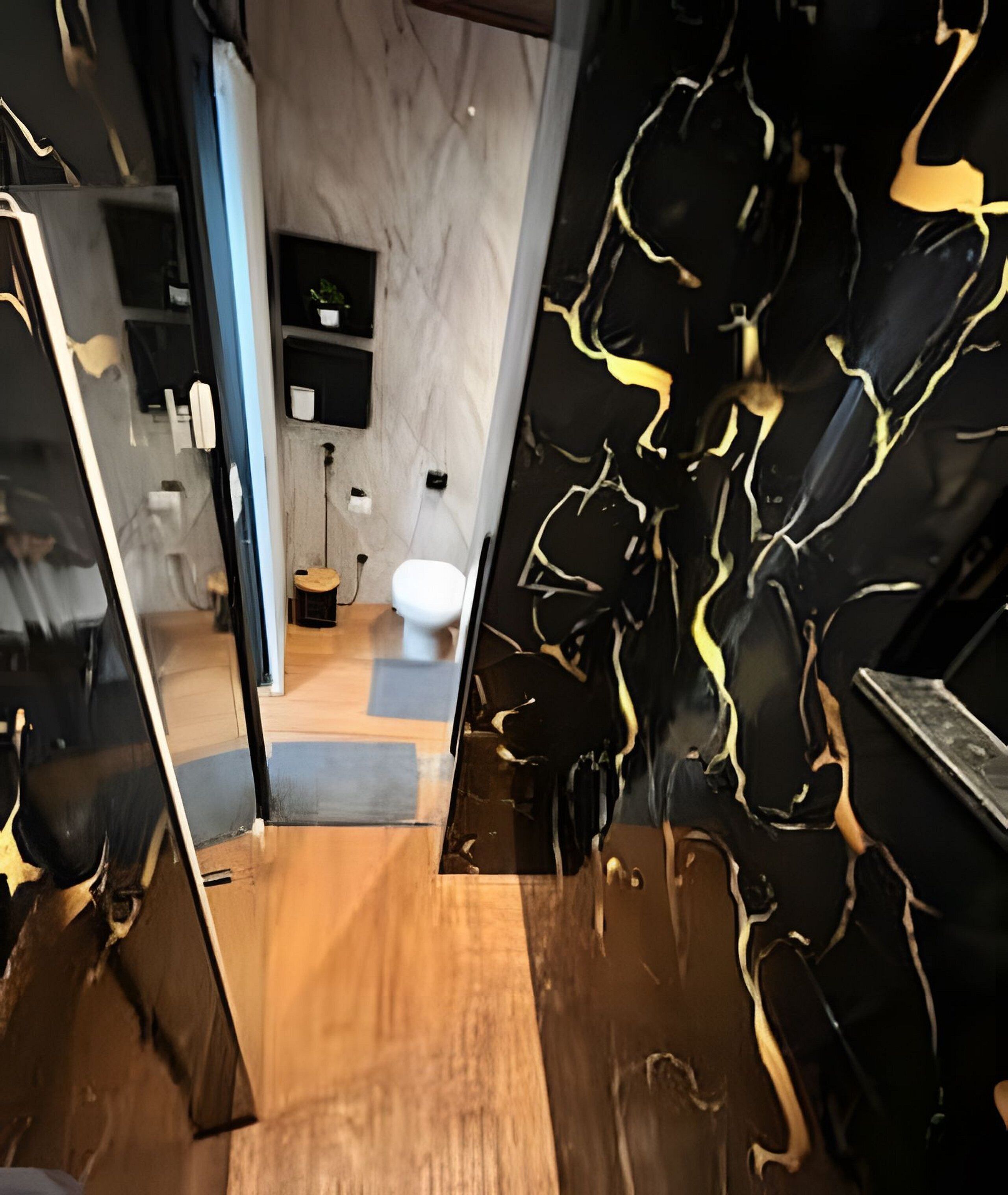 Un baño moderno con pared de mármol, inodoro y suelo de madera.