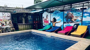Piscina con sillones de descanso y zona de bar.