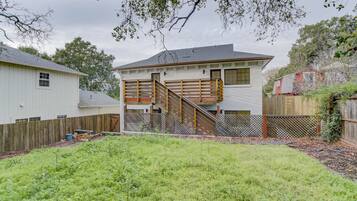 Una casa de dos pisos con una escalera de madera que lleva a una terraza.