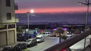 Un'area di parcheggio con veicoli e vista sull'oceano al crepuscolo.