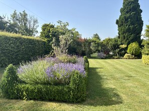 A well-maintained garden with a variety of plants and a neatly trimmed lawn. - Ashclose Lodge Annexe -  Sherborne, Dorset (Sherborne)