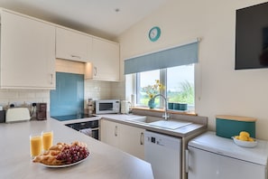 A modern kitchen with white cabinets, a microwave, a toaster, and a sink. - Ashclose Lodge Annexe -  Sherborne, Dorset (Sherborne)