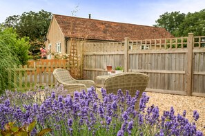 A garden with lavender plants, a wooden fence, and a house with a tiled roof. - Ashclose Lodge Annexe -  Sherborne, Dorset (Sherborne)