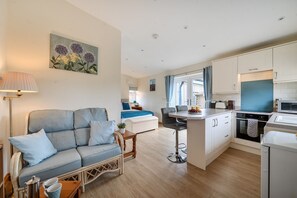 A modern apartment with a living area, kitchenette, and a dining space. - Ashclose Lodge Annexe -  Sherborne, Dorset (Sherborne)