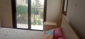 A bedroom with a bed, a window, and a view of the outside. - 3-bedroom apartment in peaceful Oroklini with cool AC.family friendly (Oroklini)
