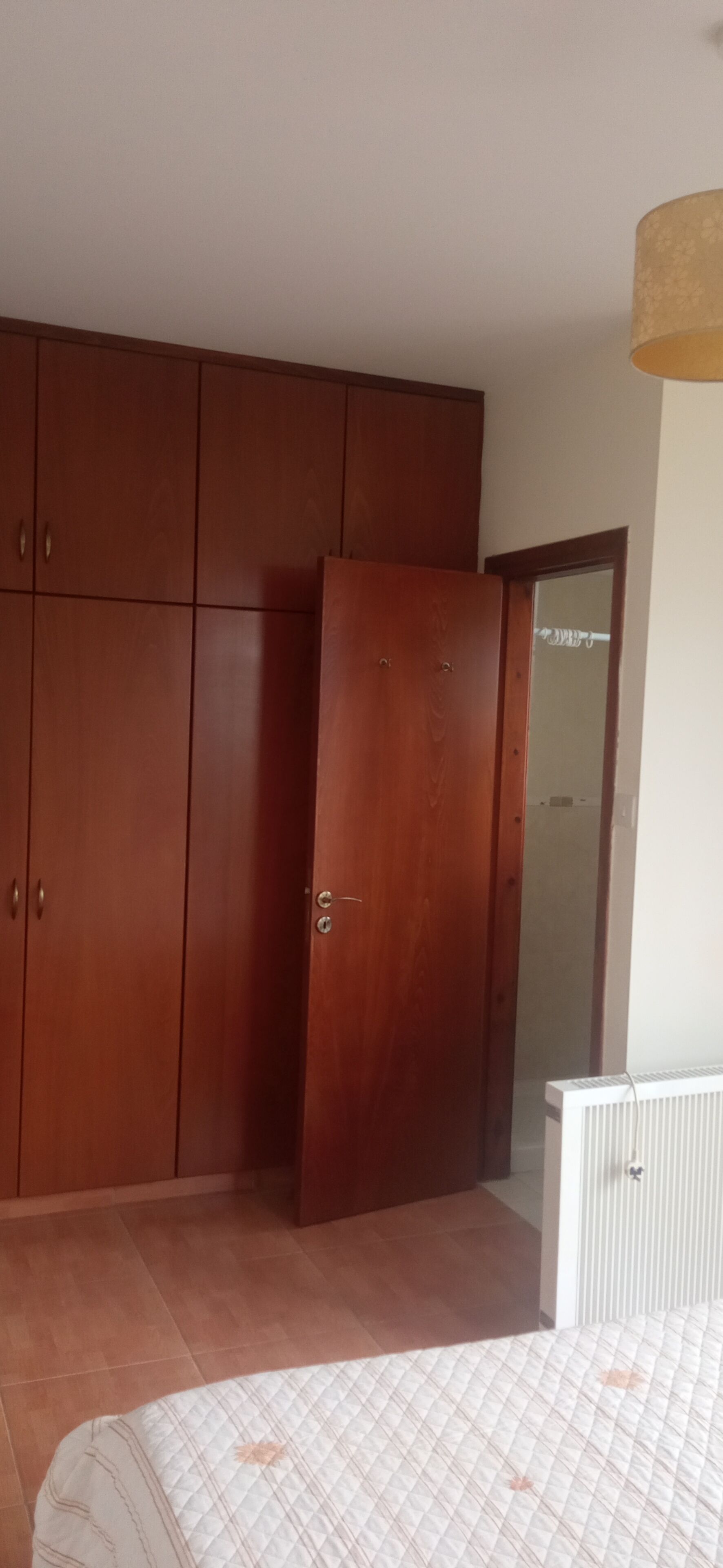 Ein Schlafzimmer mit einem Bett, einem Kleiderschrank und einer Heizung.