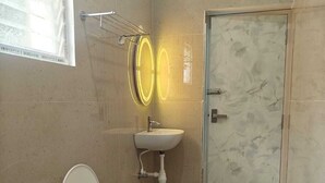 Un bagno con il water, un lavandino, uno specchio e una porta.