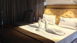 Una camera d'albergo con un letto grande, una testiera e una ventola a soffitto.