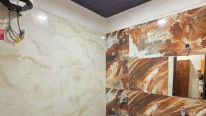 Une salle de bain avec des toilettes, un lavabo et un mur en marbre.