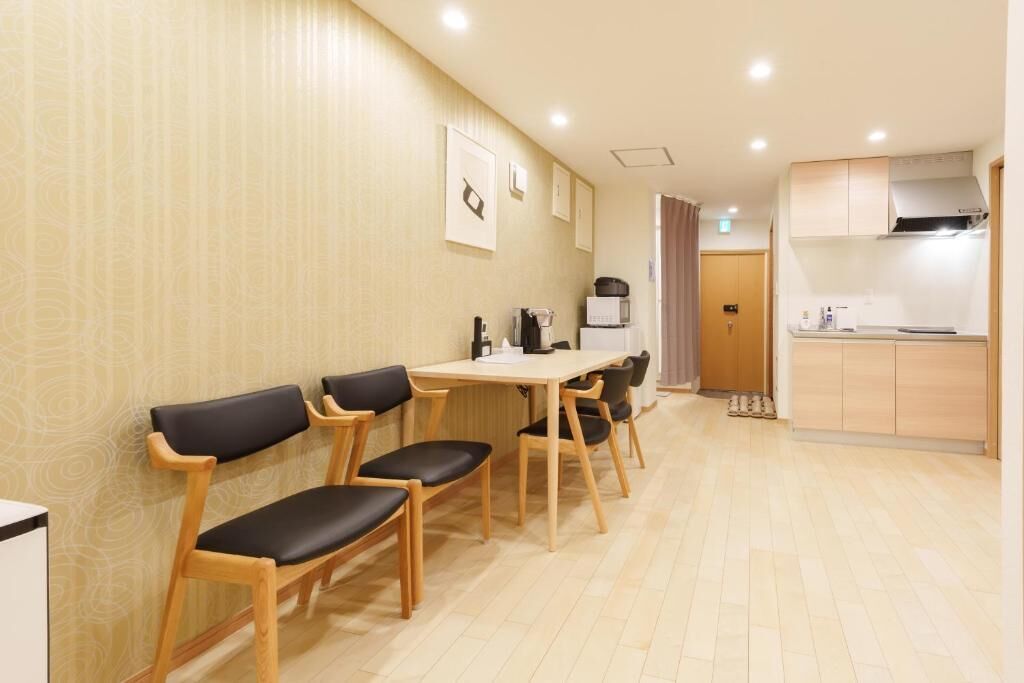 A modern kitchen with wooden cabinets and a dining area with wooden chairs and a table.