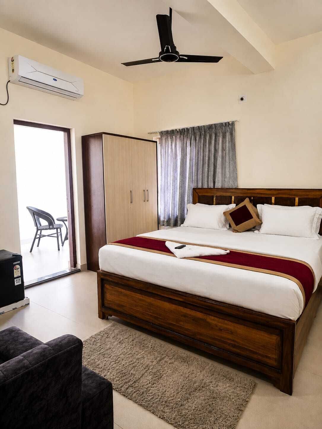 Un dormitorio con cama, armario, ventilador de techo y vistas al exterior.