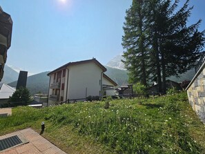 A building with a sloped roof, a balcony, and a view of mountains. - Chateau EG by Interhome (Saas-Fee)