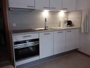A modern kitchen with a built-in oven, a sink, and a coffee maker. - Apartment Anis by Interhome (Saas-Almagell)