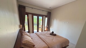 Un dormitorio con cama, cortinas, una ventana y vistas a zonas verdes.