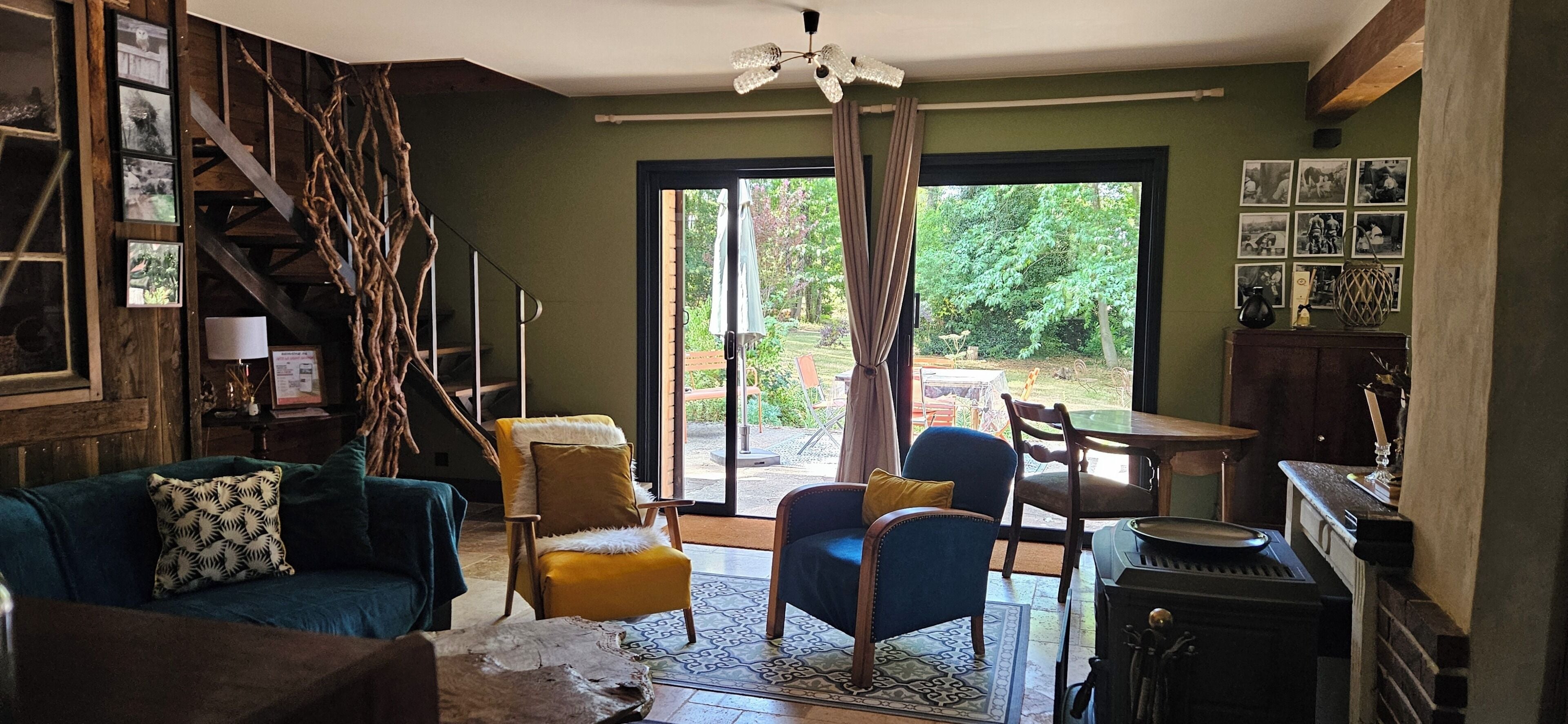 Una sala de estar acogedora con chimenea, una escalera y vistas al exterior.