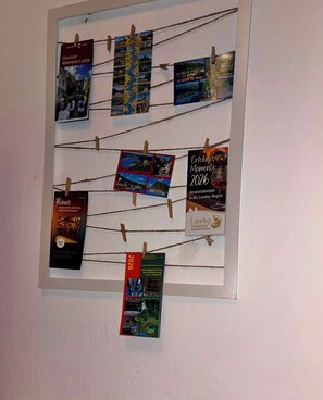 A bulletin board with various travel brochures and postcards pinned to it.