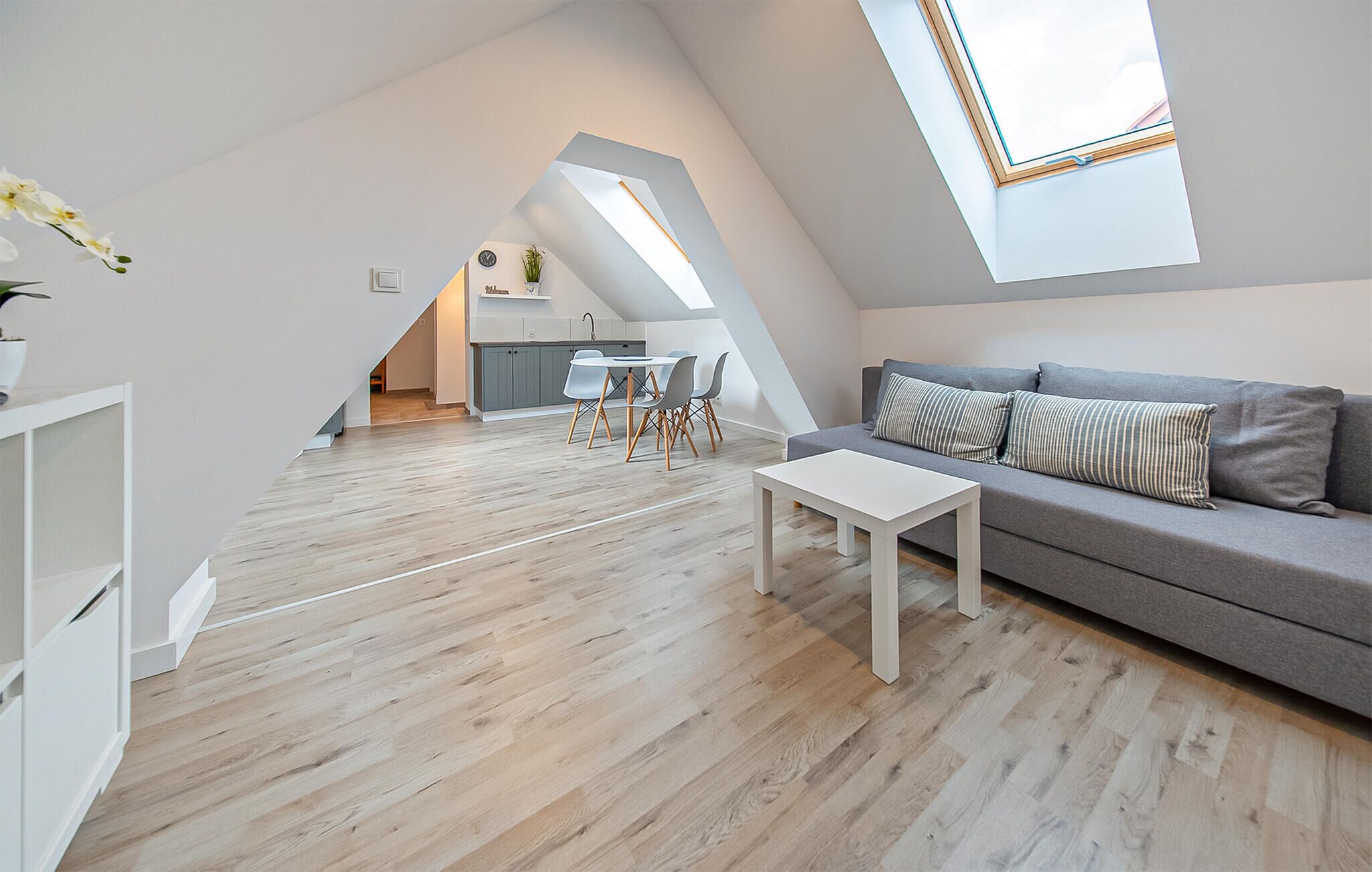 Un loft moderno con comedor, cocina y sala de estar con sofá y mesa de centro.