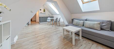 Un loft moderno con comedor, cocina y sala de estar con sofá y mesa de centro.
