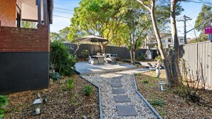 A backyard with a patio, outdoor furniture, a pathway, and a fence. - Spacious 4-bed Character House in Vibrant Stanmore (Sydney)