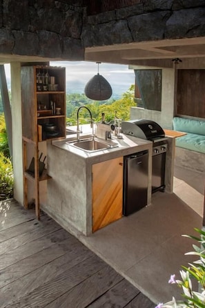 A compact kitchen with a sink, a built-in oven, and a refrigerator.