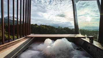 A hot tub with a view of a mountainous landscape.
