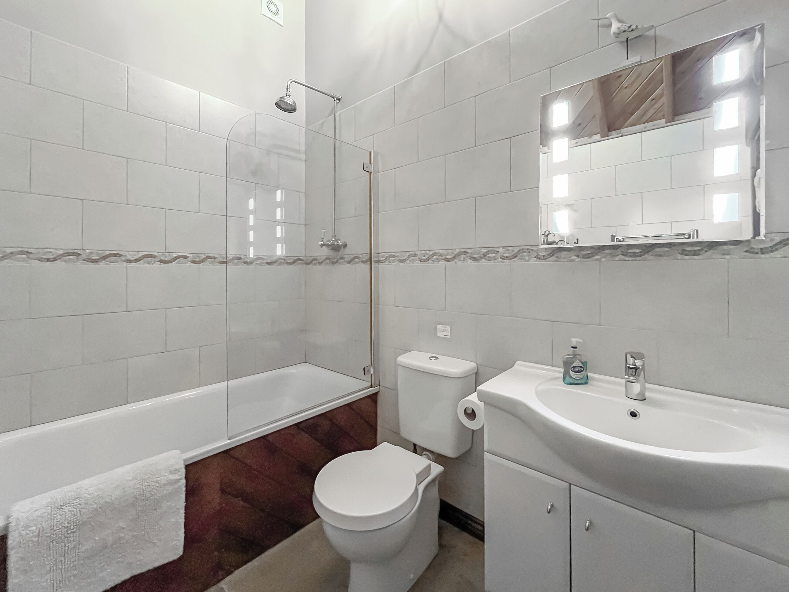 Een badkamer met bad, toilet en wastafel.