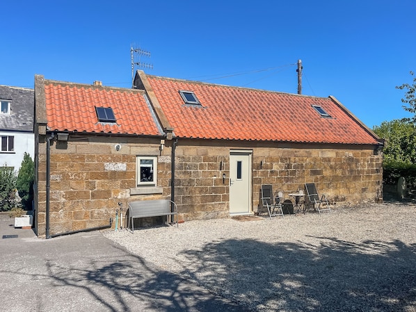 A stone building with a red-tiled roof, a door, and a small window. - Stable Cottage - UK52294 (Fylingdales)