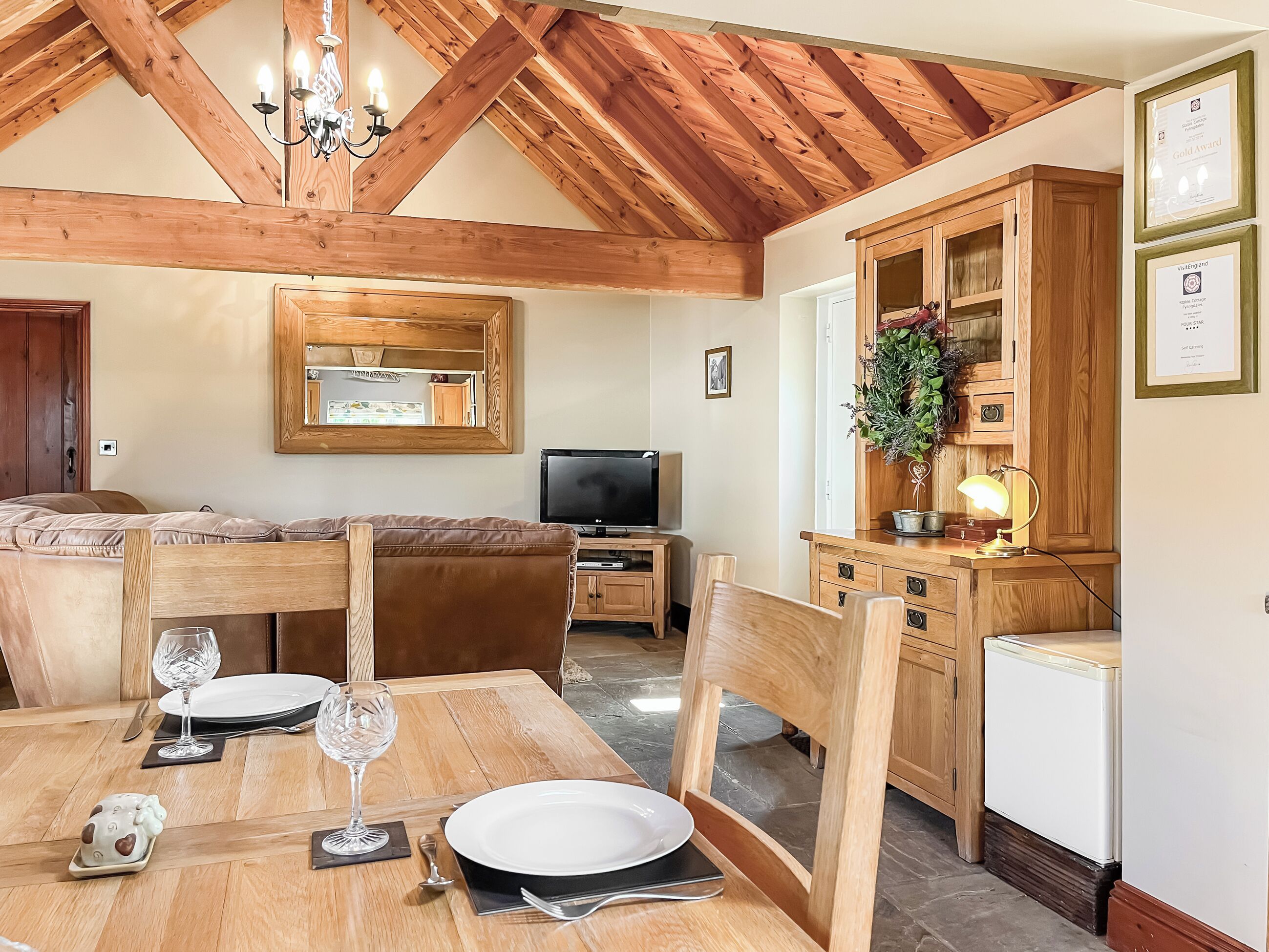 A dining area with a wooden table, chairs, and a television.