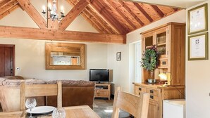 Un'area pranzo con un tavolo in legno, sedie e una televisione.