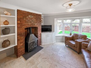 A living room with a brick fireplace, white shelving, a leather sofa, and a television. - 2 bedroom accommodation in Hamsterley, near Bishop Auckland (Hamsterley, near Bishop Auckland)