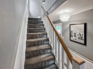 A staircase with a wooden handrail and a wall-mounted light fixture. - 2 bedroom accommodation in Hamsterley, near Bishop Auckland (Hamsterley, near Bishop Auckland)
