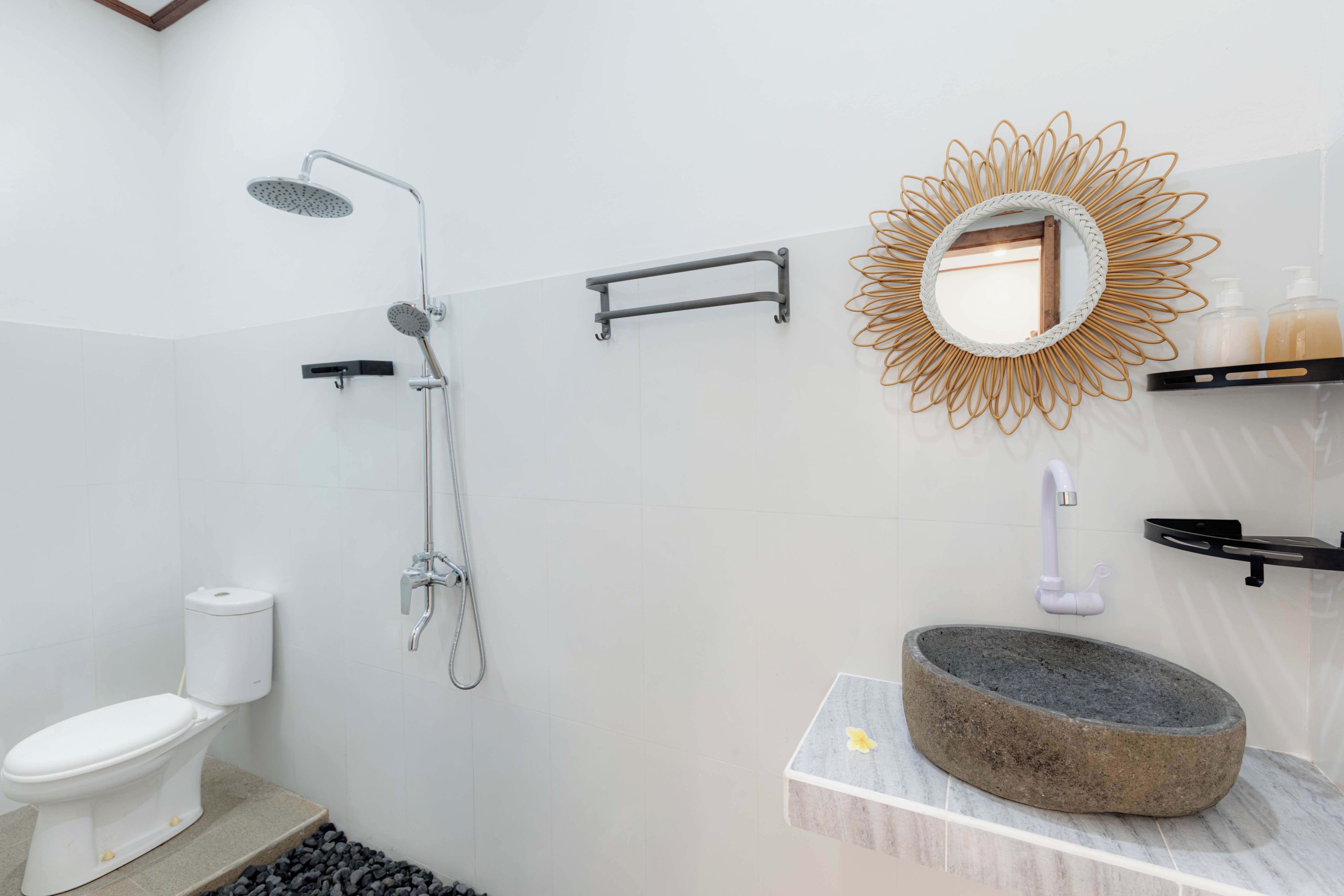 A bathroom with a shower, toilet, and a sink with a stone basin.