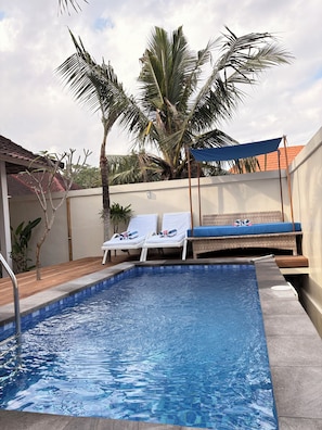 Una piscina al aire libre, sombrillas, tumbonas