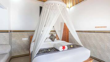 Une chambre d’hôtel avec un lit, une tête de lit en bois, un baldaquin et un sol carrelé.