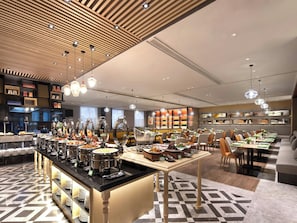 Un espace buffet doté de plusieurs points de service, proposant une grande variété de plats et bénéficiant d'un aménagement intérieur moderne.