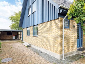A two-story building with a blue exterior and a brick facade. - 6 Person Holiday Home in Stokkemarke (Stokkemarke)