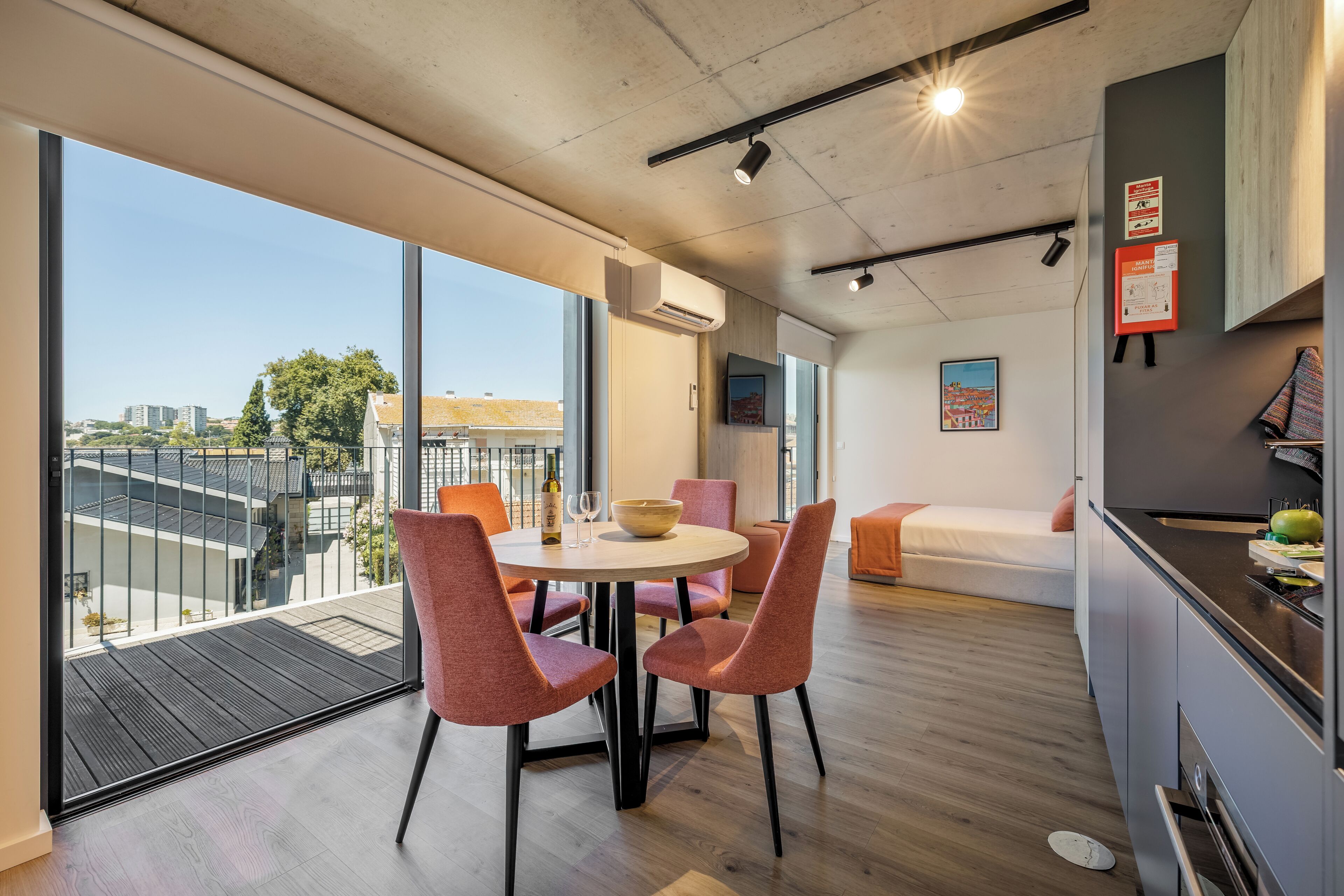A modern apartment with a balcony, a dining area, a kitchen, and a living space.
