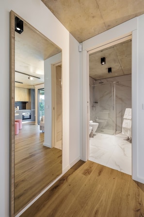 A modern bathroom with a glass shower enclosure, marble flooring, and a visible toilet. - Marina da Afurada Apartments (Vila Nova de Gaia)